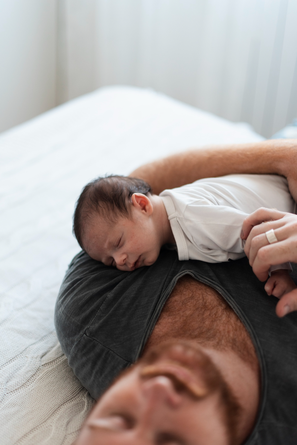 neonato dorme sul petto del padre